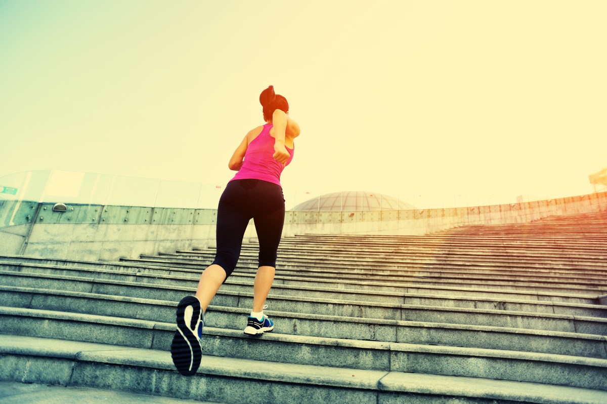 young fitness woman running up on stairs