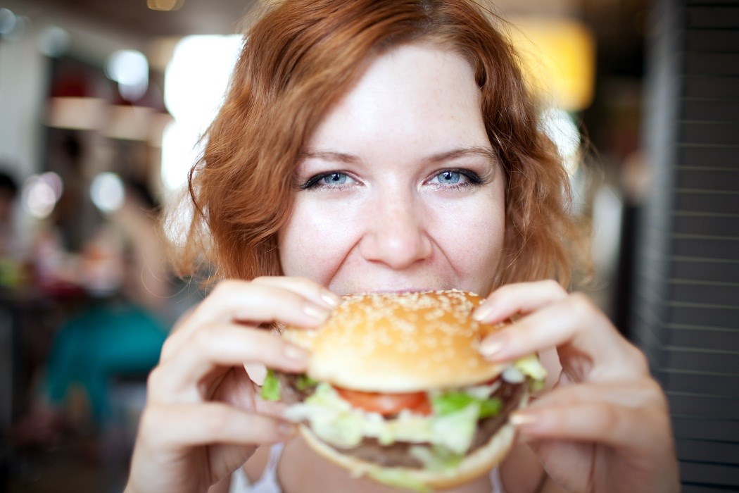 woman-eating-hamburger-eat-healthy-while-out